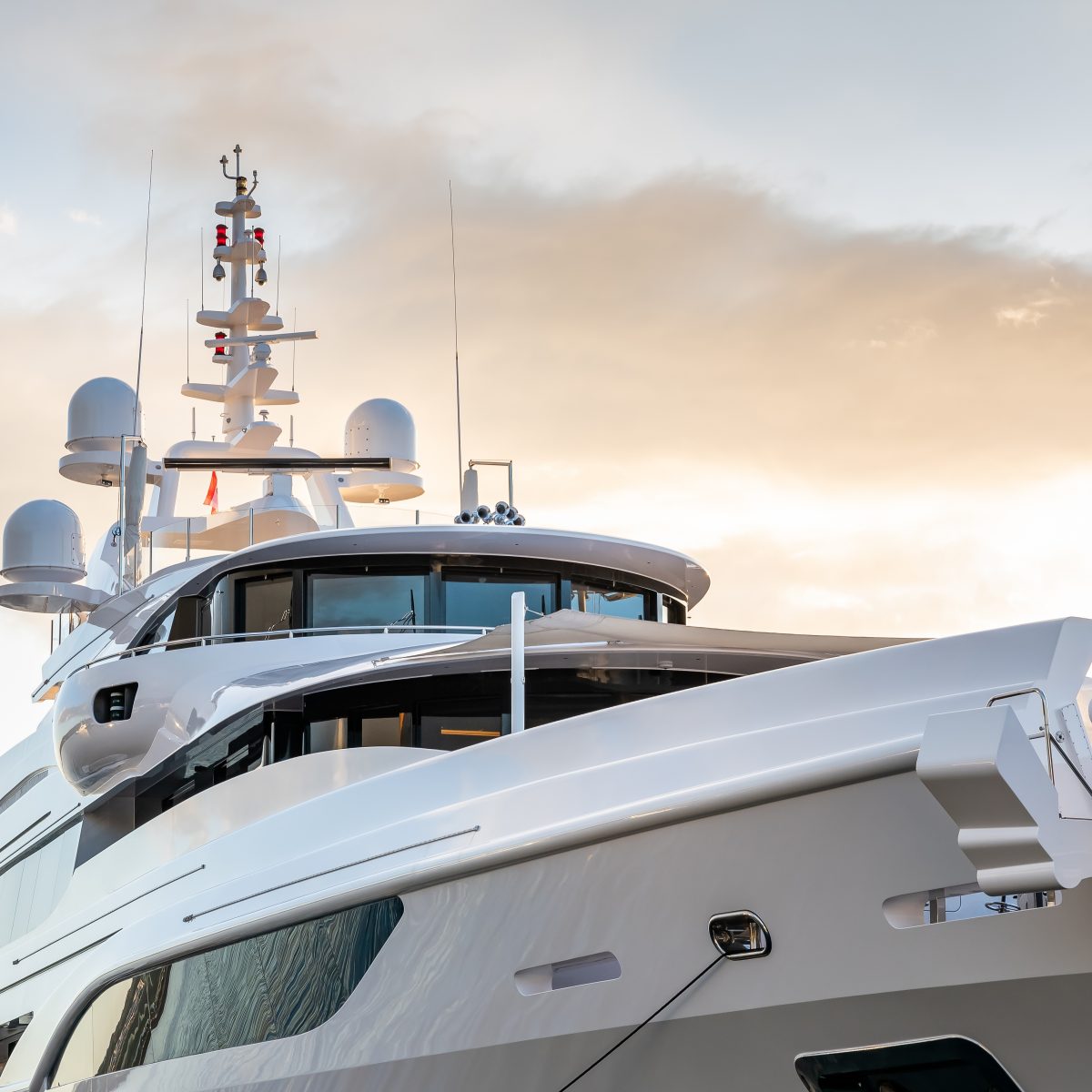 Image of the starboard side of the bow of a beige and white superyacht